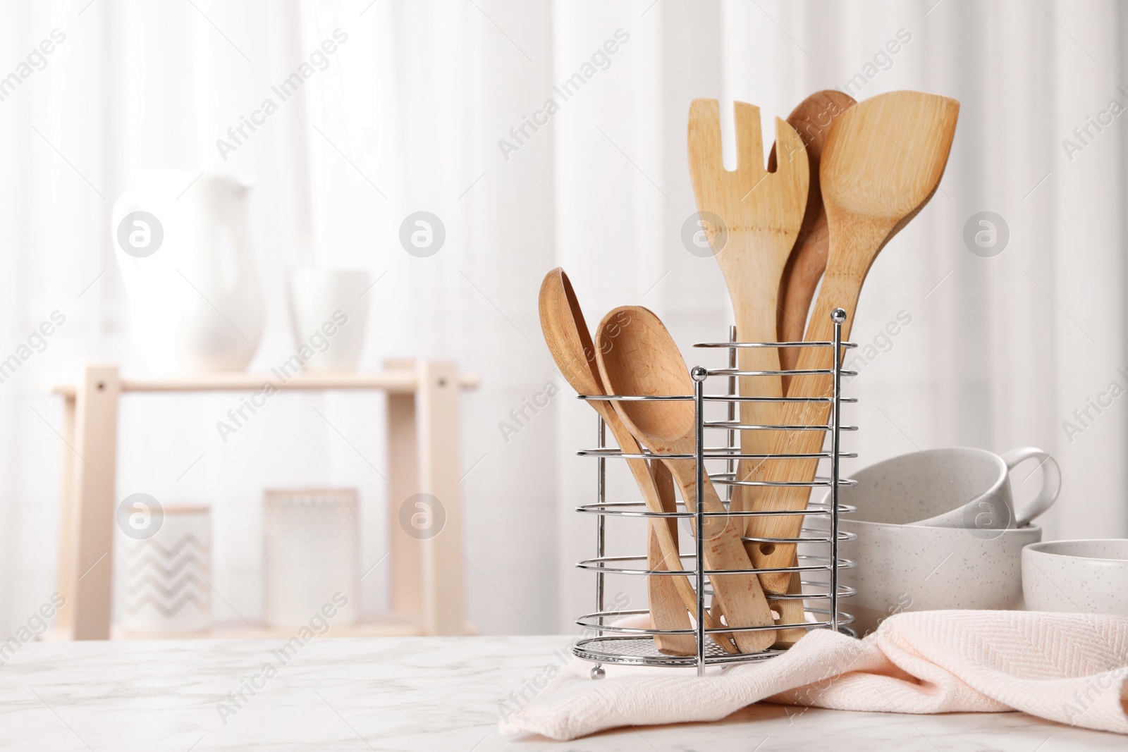 Photo of Wooden utensils and dishware on table in kitchen. Space for text