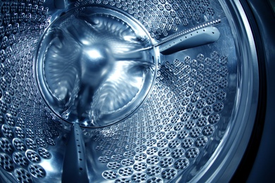 Photo of Empty washing machine drum, closeup view. Laundry day