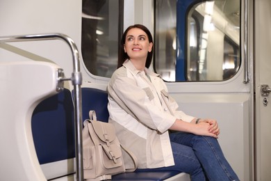 Photo of Beautiful woman with backpack in subway train. Public transport