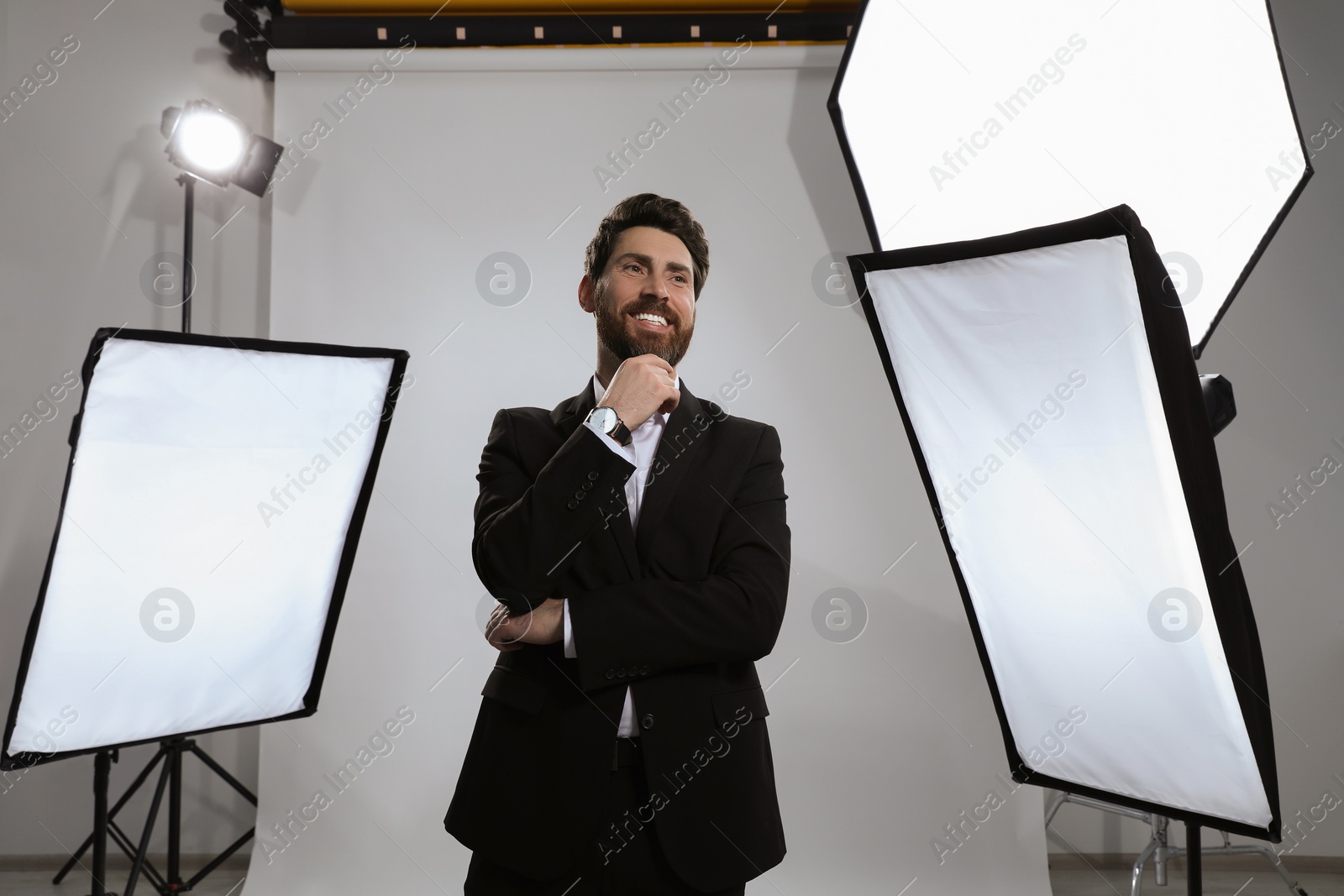 Photo of Handsome model posing in modern studio. Professional photo session