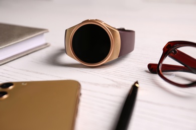 Photo of Composition with stylish smart watch on white wooden table, closeup