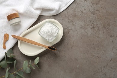 Flat lay composition with tooth powder and eucalyptus on grey table, space for text