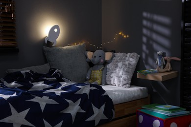 Photo of Rocket shaped night lamp on wall in child's room