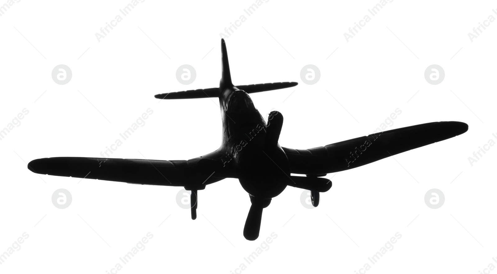 Photo of Dark silhouette of vintage toy military airplane on white background