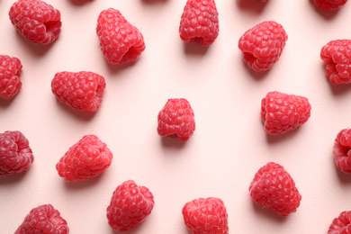 Photo of Fresh sweet ripe raspberries on pink background, flat lay