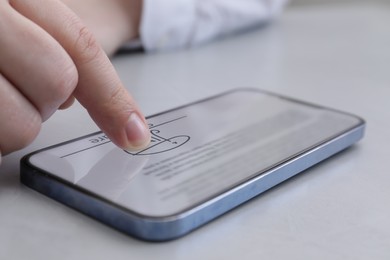 Image of Electronic signature. Man using mobile phone at table, closeup