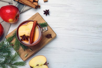 Aromatic hot mulled cider on white wooden table, flat lay. Space for text