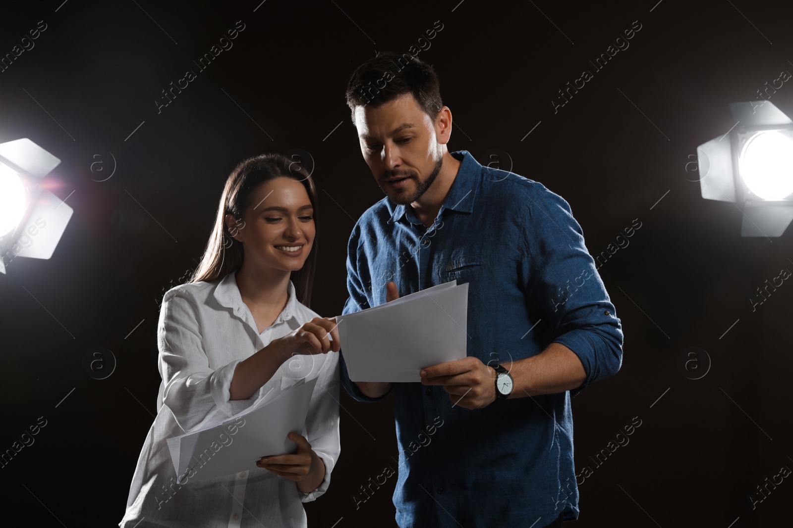 Photo of Professional actors reading their scripts during rehearsal in theatre