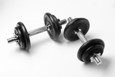 Photo of Metal dumbbells isolated on white. Sports equipment