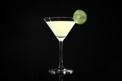 Glass of delicious cucumber martini on dark background