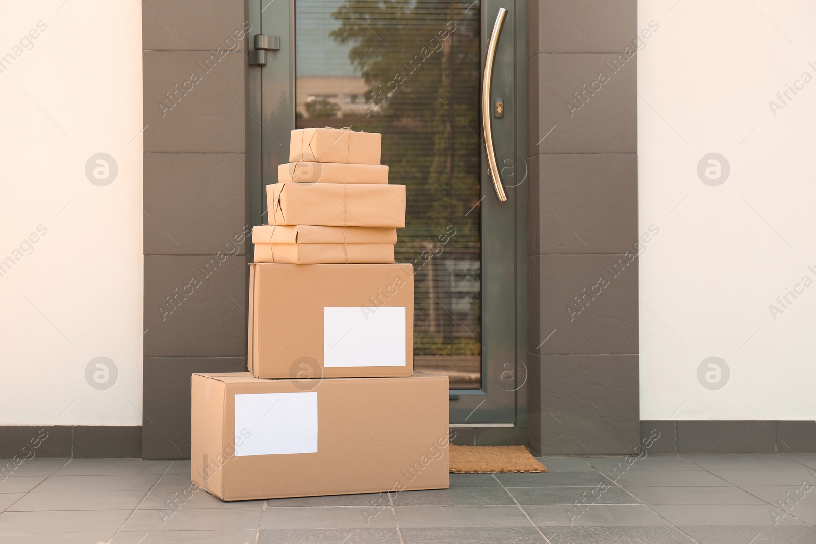 Photo of Cardboard boxes near door. Parcel delivery service