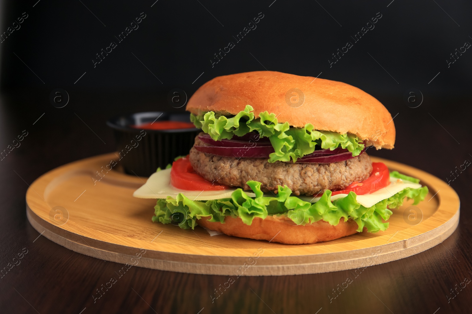 Photo of Tasty burger with vegetables, patty and cheese on wooden table, closeup