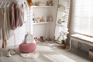 Photo of Rack with different stylish clothes, shoes and decorative elements in dressing room. Interior design