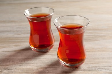 Photo of Glasses of traditional Turkish tea on white wooden table, closeup