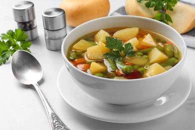 Bowl of delicious turnip soup served on white table