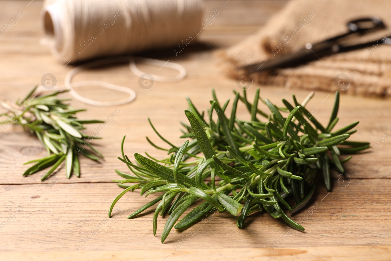 Photo of Fresh green rosemary on wooden table, closeup