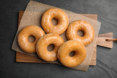 Photo of Delicious donuts on black table, top view