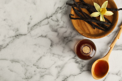 Photo of Flat lay composition with vanilla extract on marble table. Space for text