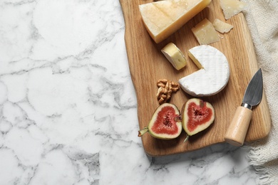 Different delicious cheeses served on marble table, top view. Space for text