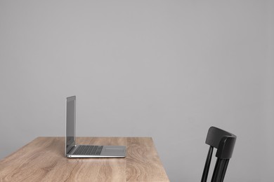Photo of New modern laptop on empty wooden table indoors, space for text