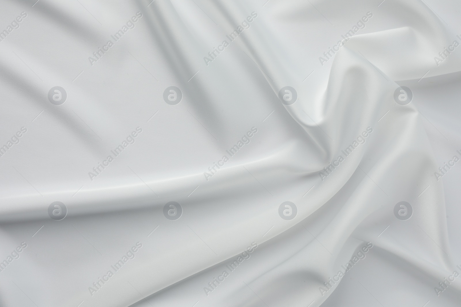 Photo of Texture of crumpled white silk fabric as background, top view