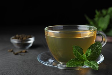 Cup of hot aromatic mint tea on grey table