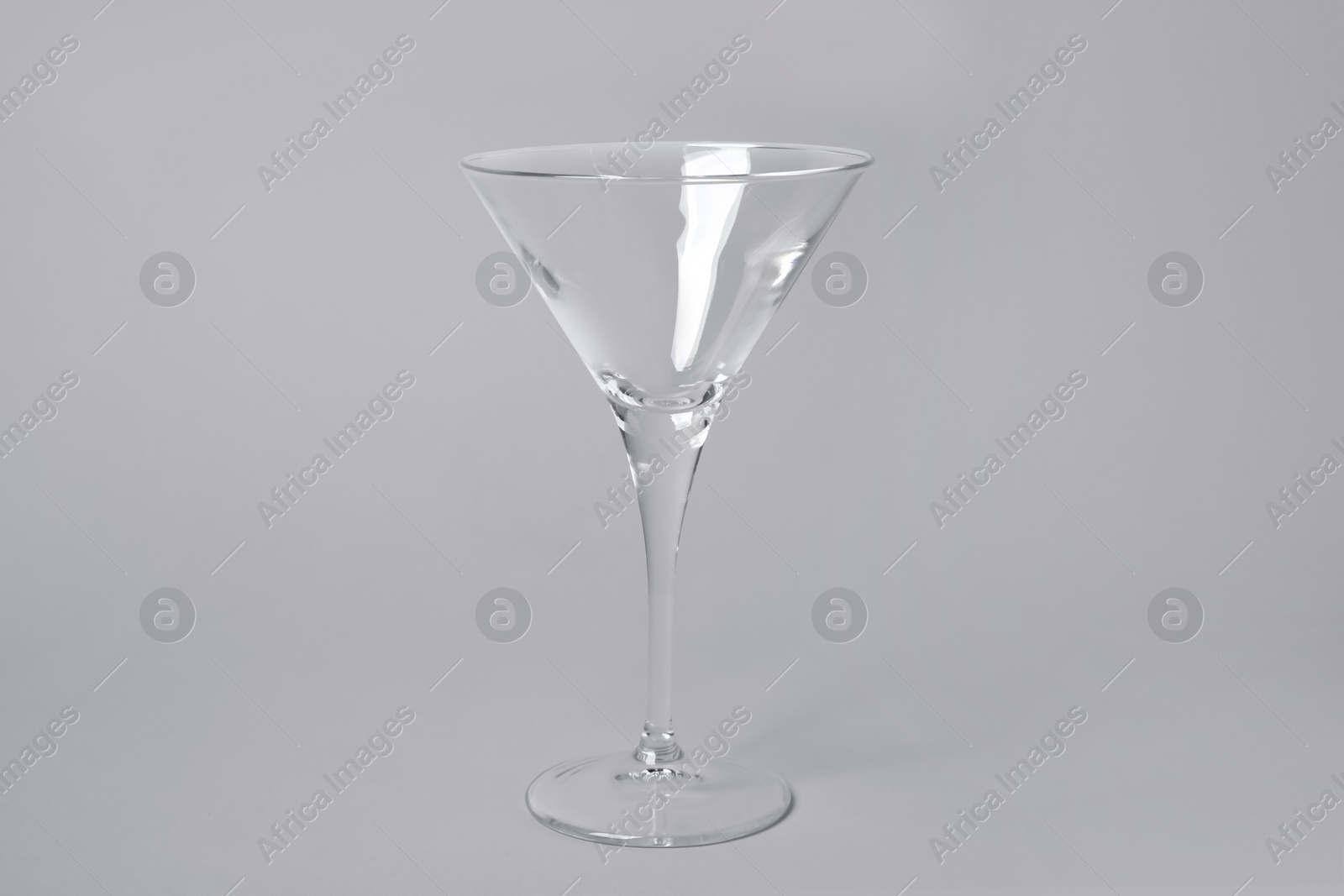 Photo of Empty clean martini glass on grey background