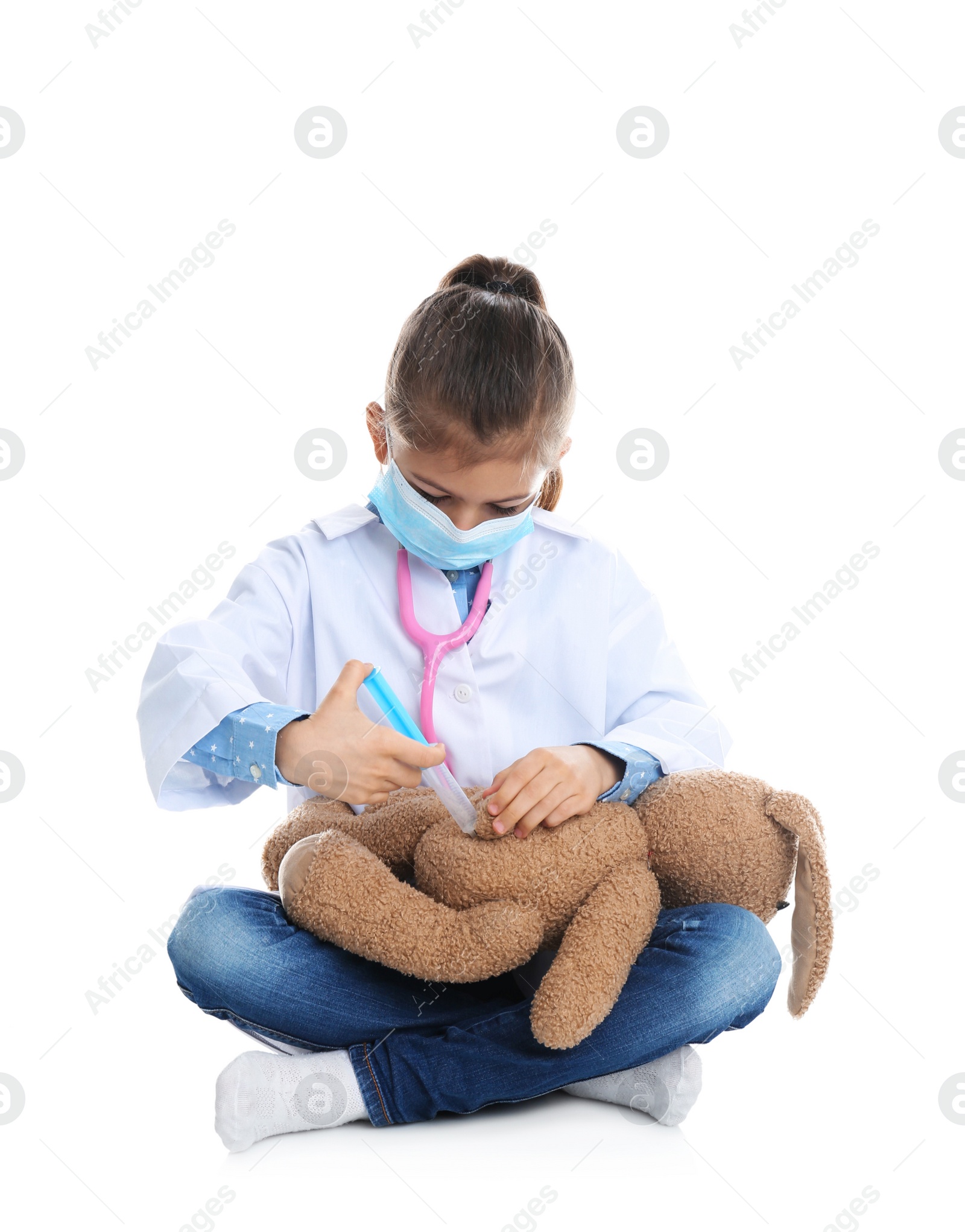 Photo of Cute child playing doctor with stuffed toy on white background