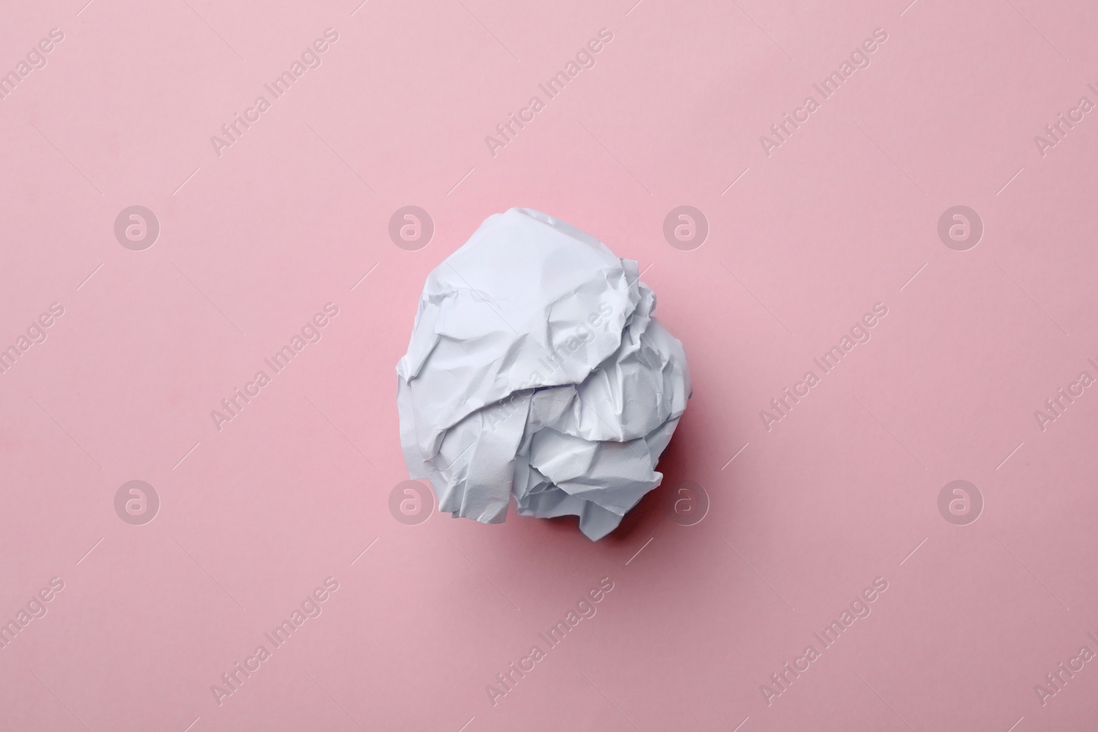 Photo of Crumpled sheet of paper on color background, top view