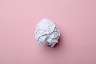 Crumpled sheet of paper on color background, top view