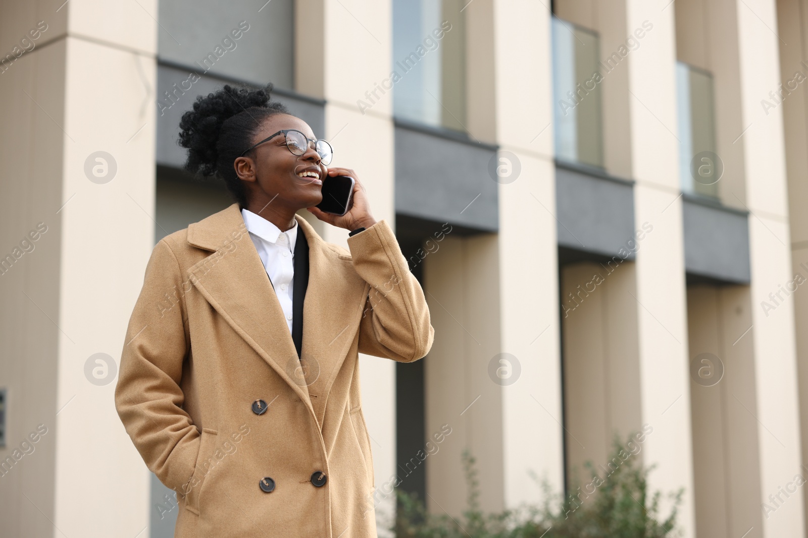 Photo of Happy woman talking on smartphone outdoors, space for text. Lawyer, businesswoman, accountant or manager