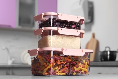 Stacked boxes with different food on table in kitchen