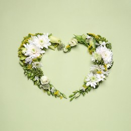 Photo of Beautiful heart shaped floral composition on light green background, flat lay