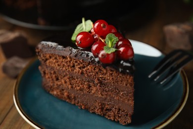 Photo of Piece of tasty homemade chocolate cake with berries and mint on plate, closeup