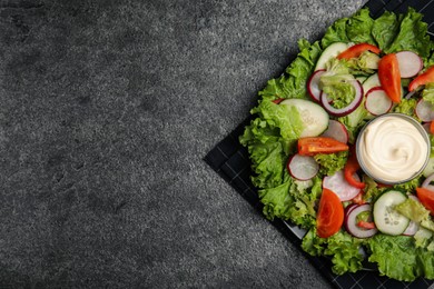 Plate of delicious vegetable salad with mayonnaise on grey table, top view. Space for text