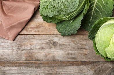 Flat lay composition with savoy cabbage and space for text on wooden background