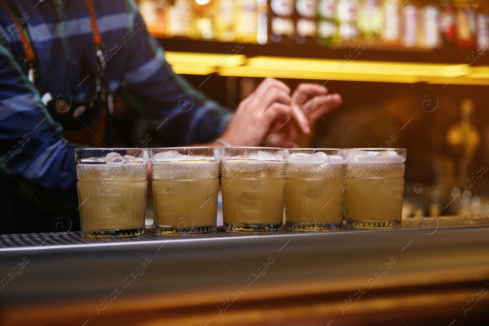 Photo of Glasses of tasty cocktail on bar counter