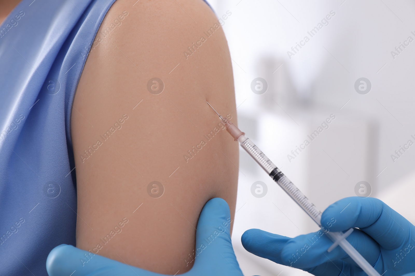 Photo of Doctor giving injection to woman in hospital, closeup. Immunization concept