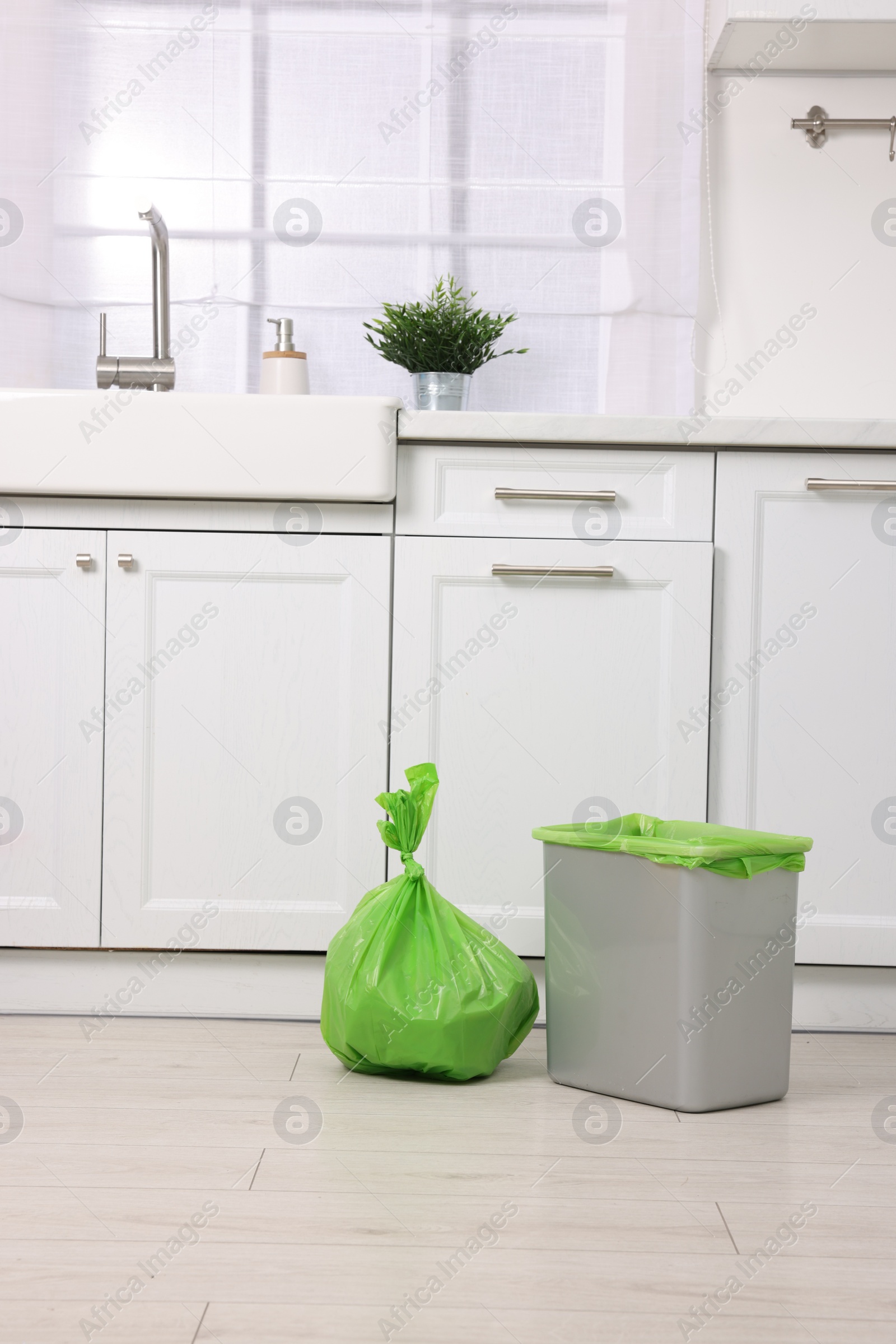 Photo of Plastic garbage bag and trash can in kitchen