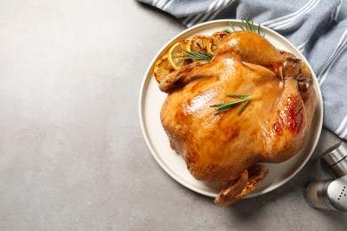 Photo of Tasty roasted chicken with rosemary and lemon on light grey table, top view. Space for text