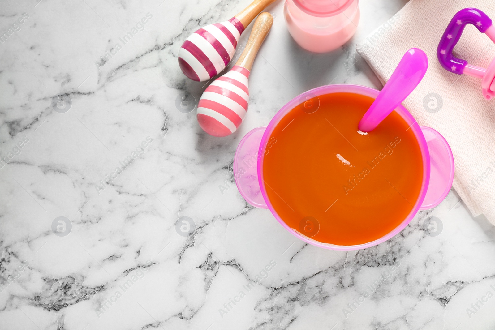 Photo of Flat lay composition with bowl of healthy baby food on white marble table. Space for text