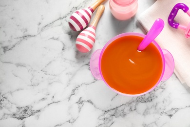 Flat lay composition with bowl of healthy baby food on white marble table. Space for text