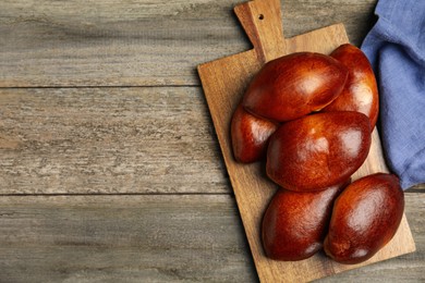 Photo of Delicious baked pirozhki on wooden table, flat lay. Space for text