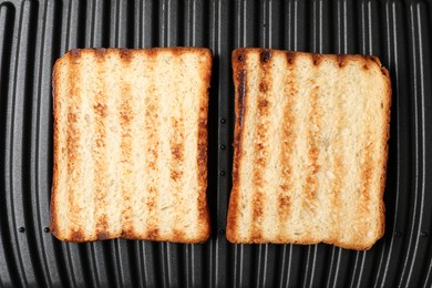 Photo of Modern sandwich maker with bread slices, top view