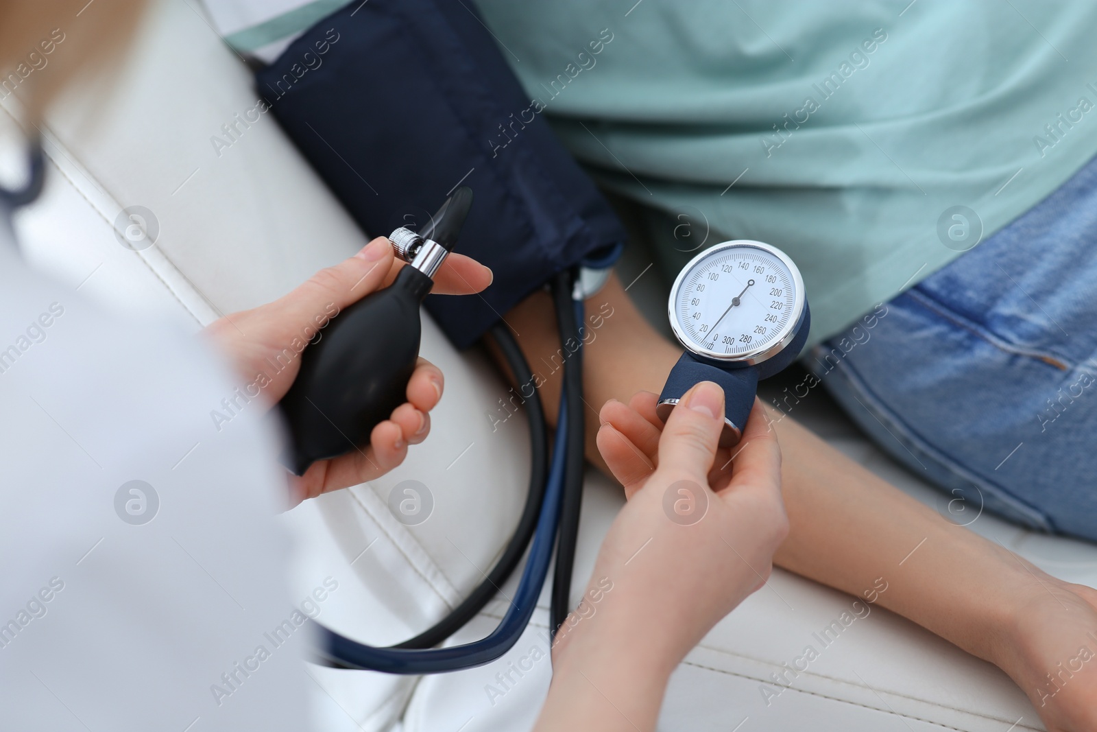 Photo of Doctor checking blood pressure of woman in clinic, closeup