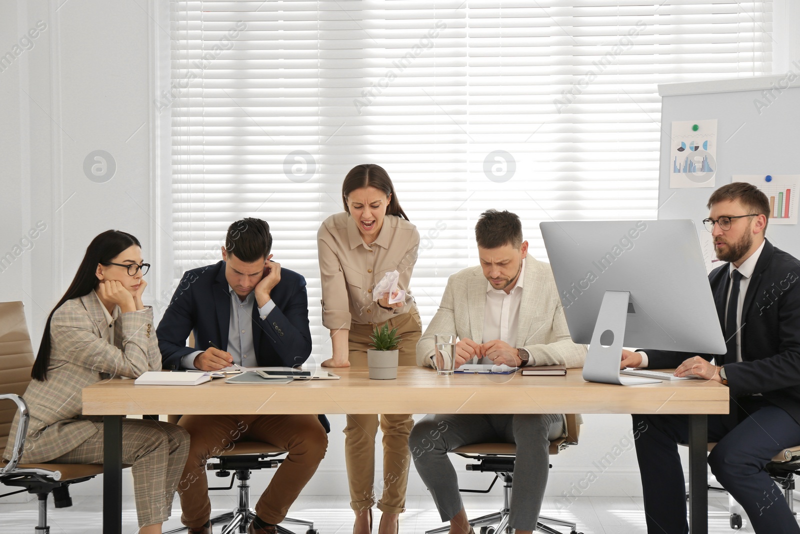 Photo of Boss screaming at employees on meeting in office. Toxic work environment