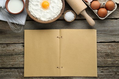 Blank recipe book and different ingredients on wooden table, flat lay. Space for text