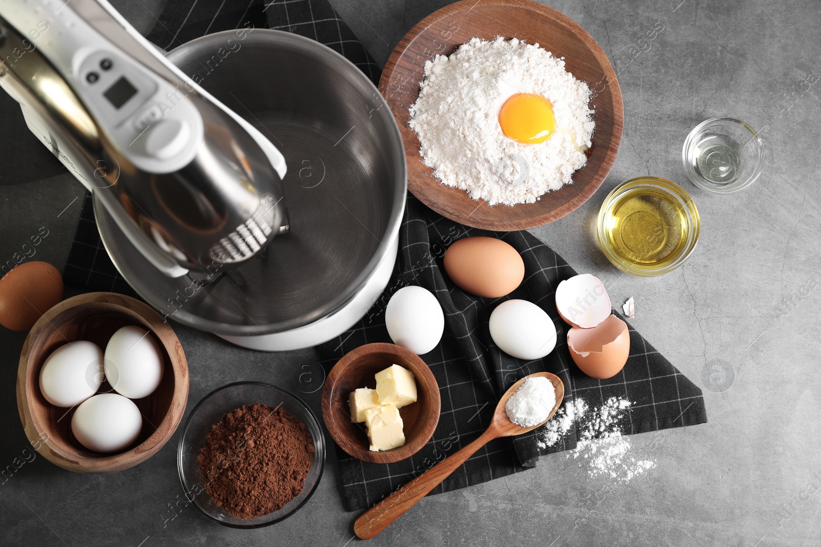 Photo of Stand mixer and different ingredients for dough on grey table, flat lay