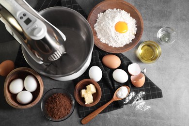 Stand mixer and different ingredients for dough on grey table, flat lay