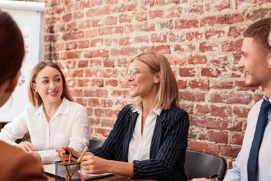 Photo of Businesswoman having meeting with her employees in office. Lady boss